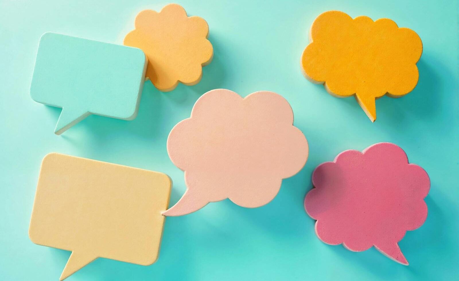 Bright pastel speech bubbles on a blue background, ideal for communication themes.